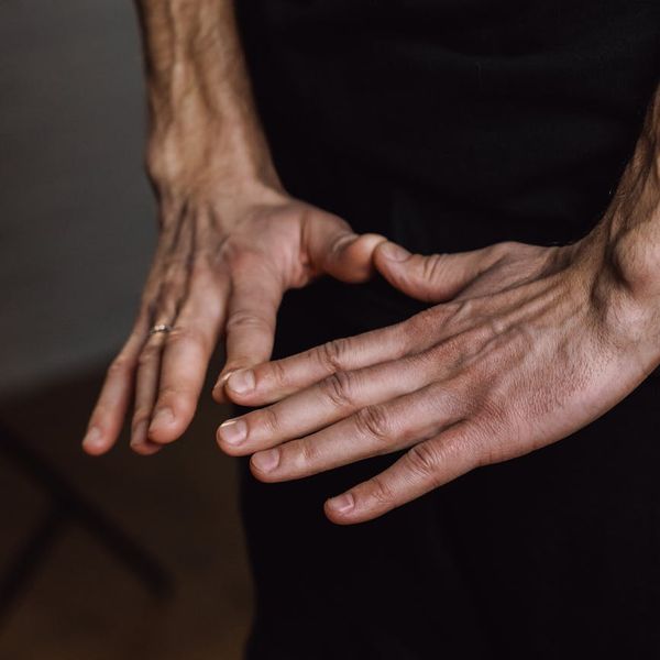 Close-up of hands in a meditative mudra gesture in a peaceful setting.